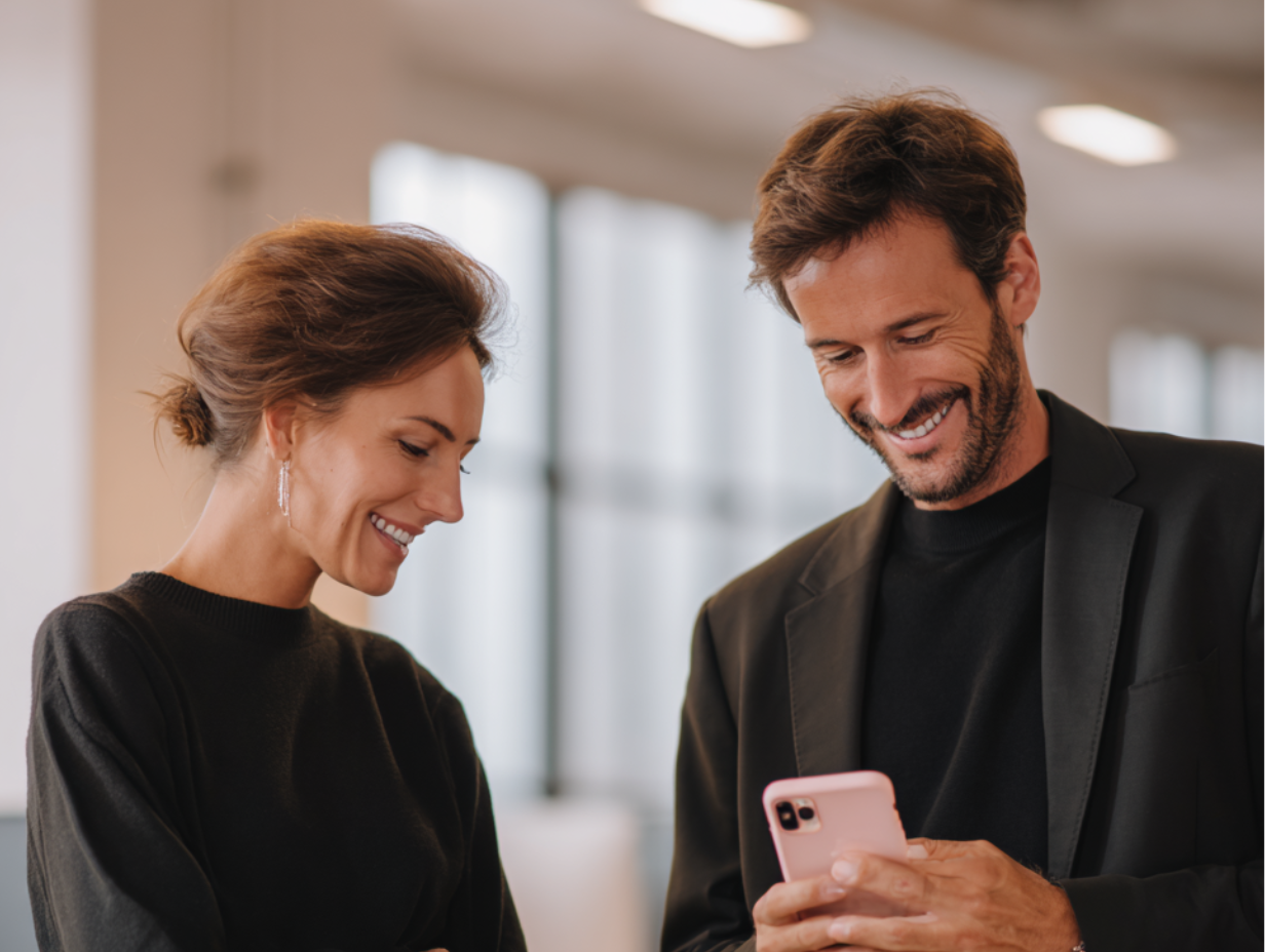 Un homme avec son téléphone dans la main et une femme sourit